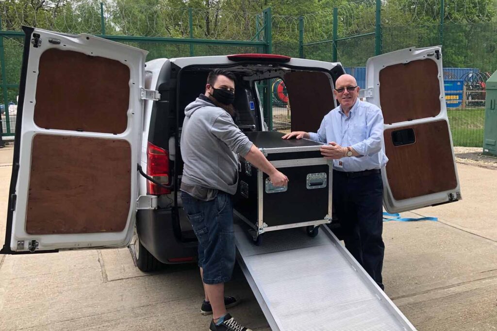 datanet staff helping clients unload flight cases from the back of a small van and into the data centre